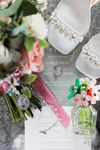 Wedding morning details at Stormont in Belfast, with shoes, bouquet, invitation and perfume arranged in soft light