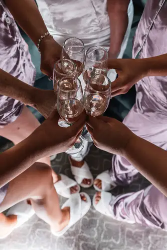 Bridesmaids in robes share a champagne toast during wedding morning prep at Stormont in Belfast.