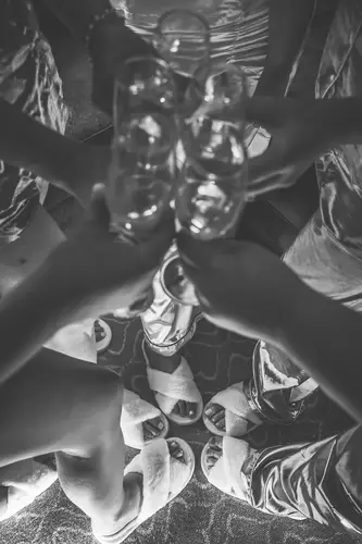 Black and white overhead photo of bridesmaids sharing a champagne toast while getting ready at Stormont in Belfast.