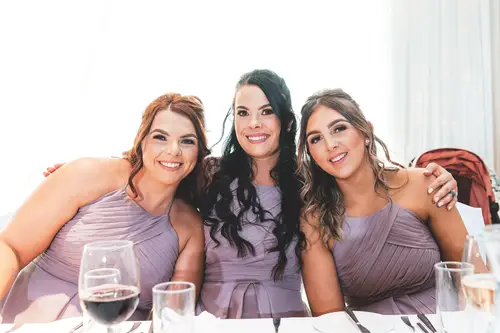 Bridesmaids in lavender dresses smiling together during a wedding reception at Stormont, Belfast