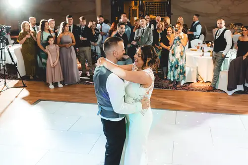 First dance at a Stormont wedding reception in Belfast, with guests gathered around the warmly lit dance floor.