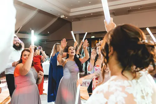 Bride and wedding guests dancing with glow sticks at a Stormont reception in Belfast