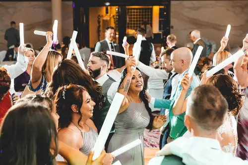 Wedding guests dancing with glow sticks during an evening reception at Stormont in Belfast