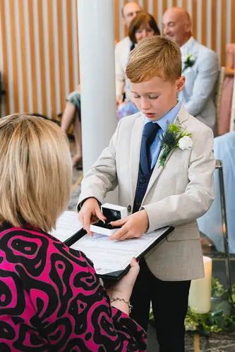 Page boy carrying wedding rings during an indoor ceremony at Ten Square in Belfast