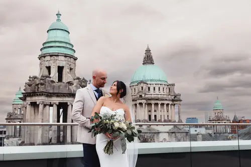 Bride and groom on the rooftop at Ten Square, Belfast, with a city backdrop and soft overcast light