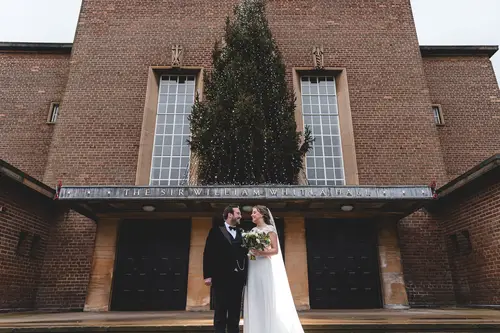Bride and groom portrait outside Ulster Museum in Belfast, with brick architecture and soft overcast light
