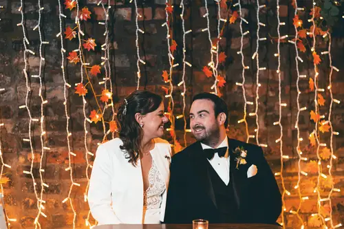 Bride and groom sharing a quiet portrait under string lights at Ulster Museum in Belfast