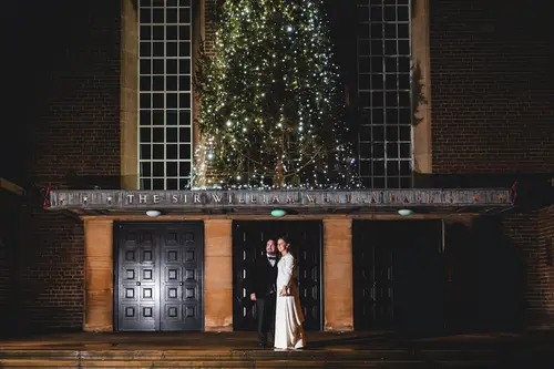 Bride and groom night portrait outside Ulster Museum in Belfast, lit by festive lights and dramatic winter lighting