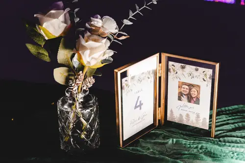 Candlelit table number and floral centrepiece at an Ulster Museum wedding reception in Belfast