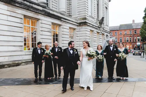 Bridal party walking outside Ulster Museum in Belfast during relaxed family portraits in natural light