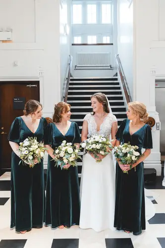 Bride and bridesmaids with bouquets on the staircase inside Ulster Museum, Belfast