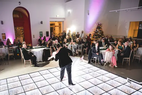 Wedding guests dancing on a bright dance floor during an evening reception at Ulster Museum in Belfast