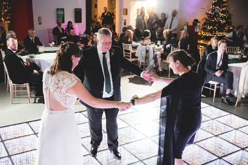 Bride dancing with family and guests on the Ulster Museum dance floor during a lively Belfast wedding reception