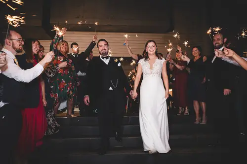 Sparkler send-off for a bride and groom with guests at Ulster Museum in Belfast at night